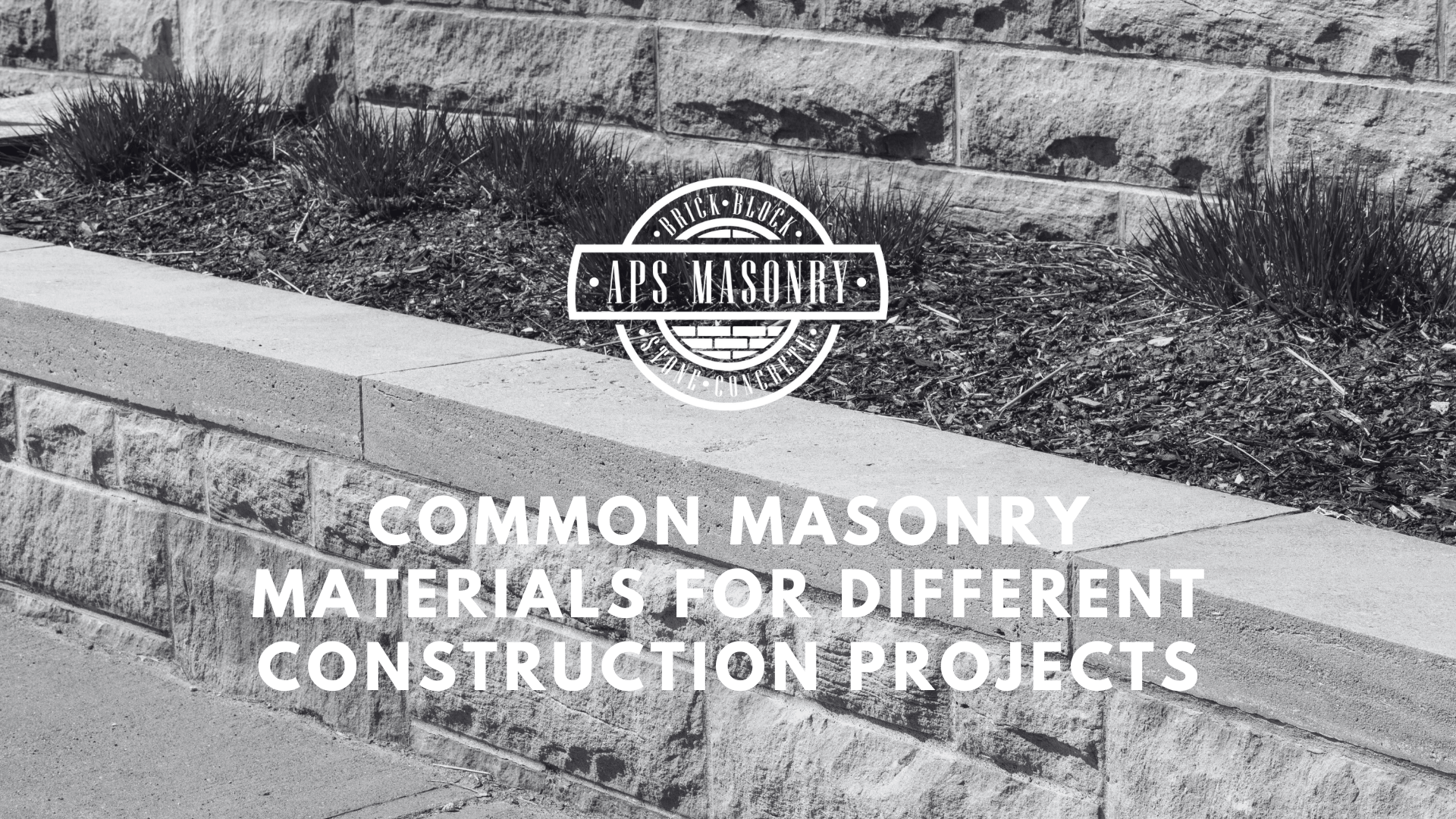 A black and white photo showcasing a neatly constructed multi-tiered masonry landscape feature with plants. In the center, the APS Masonry logo is superimposed over the stonework, with the text 