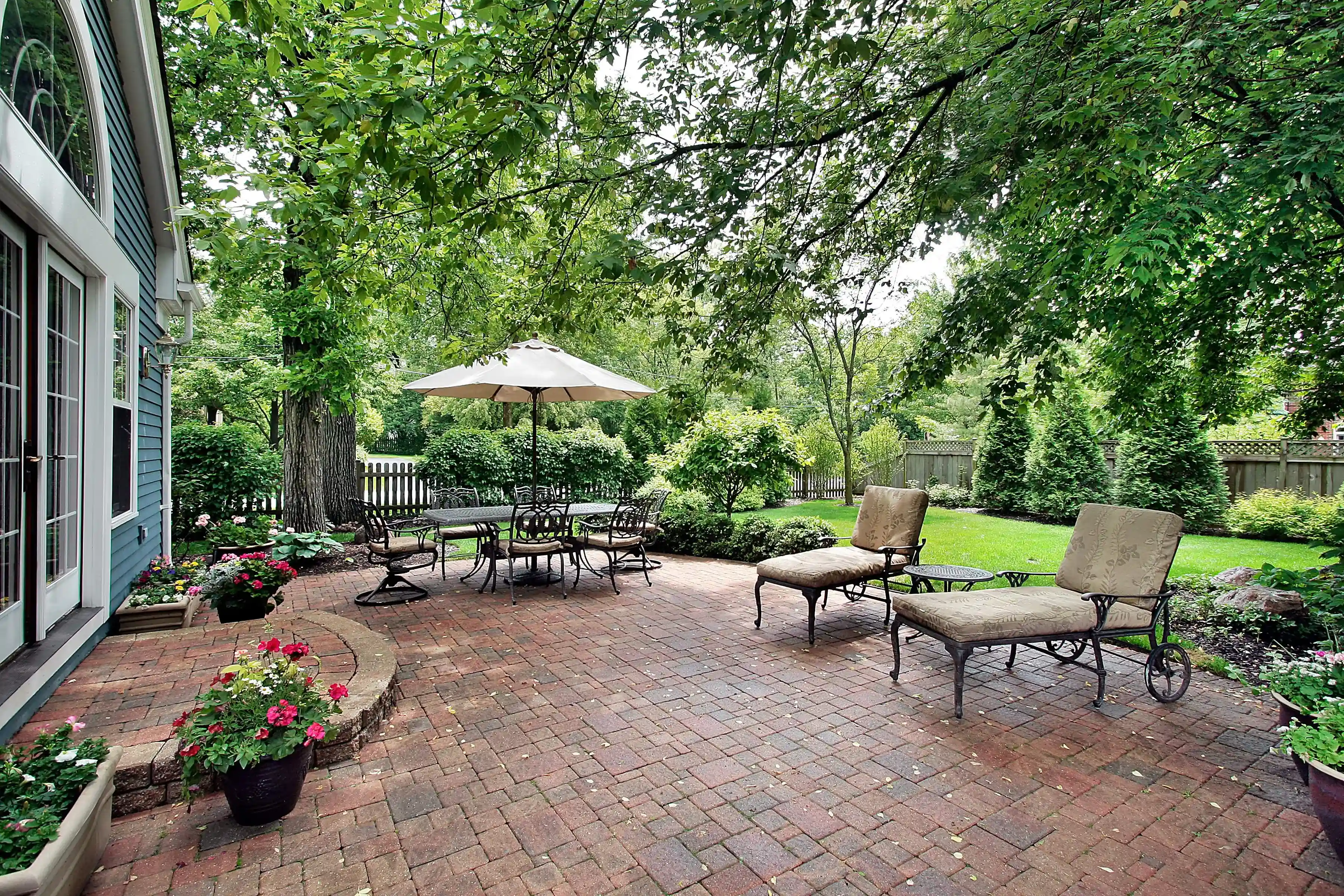 Beautiful backyard patio in Philadelphia with brick paving, outdoor furniture, and lush greenery.